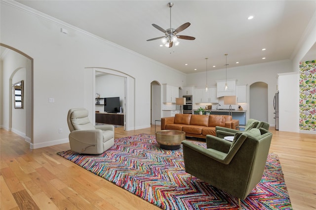 749 Lazy Brooke Dr, Rockwall, TX 75087 - living room featuring light wood-type flooring, ceiling fan, arched walkways, ornamental molding, and recessed lighting