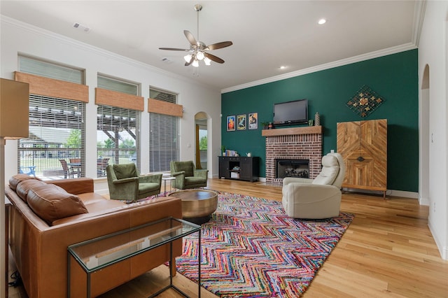 749 Lazy Brooke Dr, Rockwall, TX 75087 - living room with wood finished floors, visible vents, a ceiling fan, arched walkways, and crown molding