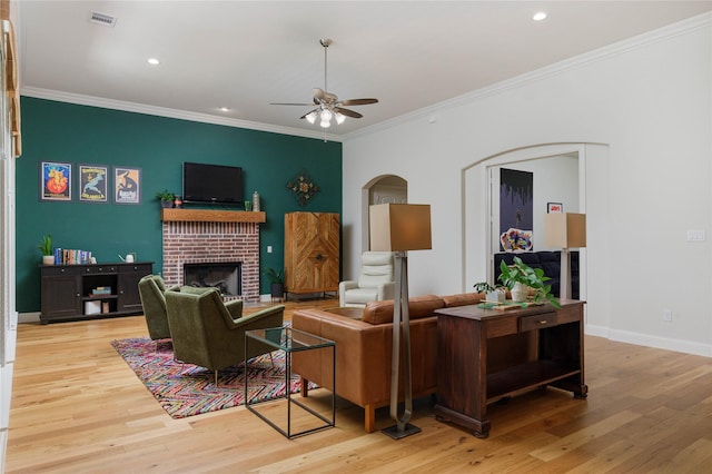 749 Lazy Brooke Dr, Rockwall, TX 75087 - living room featuring arched walkways, visible vents, a ceiling fan, wood finished floors, and a brick fireplace