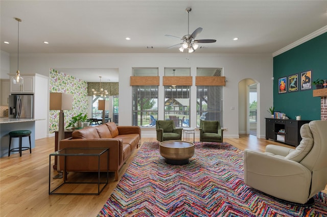 749 Lazy Brooke Dr, Rockwall, TX 75087 - living room featuring arched walkways, crown molding, light wood finished floors, and ceiling fan with notable chandelier