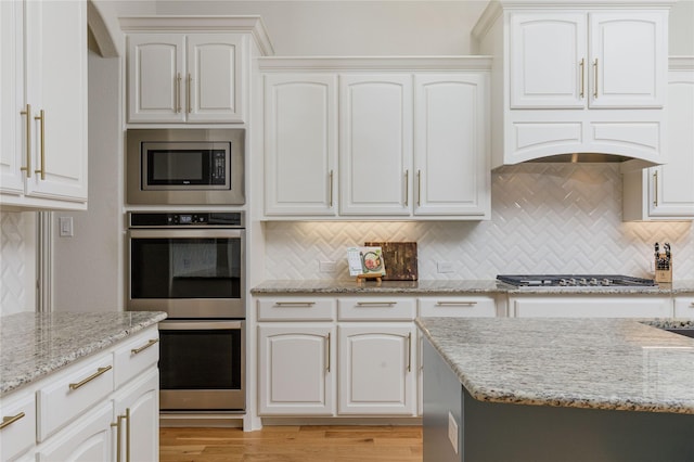 749 Lazy Brooke Dr, Rockwall, TX 75087 - kitchen featuring tasteful backsplash, light stone countertops, stainless steel appliances, and light wood-style flooring