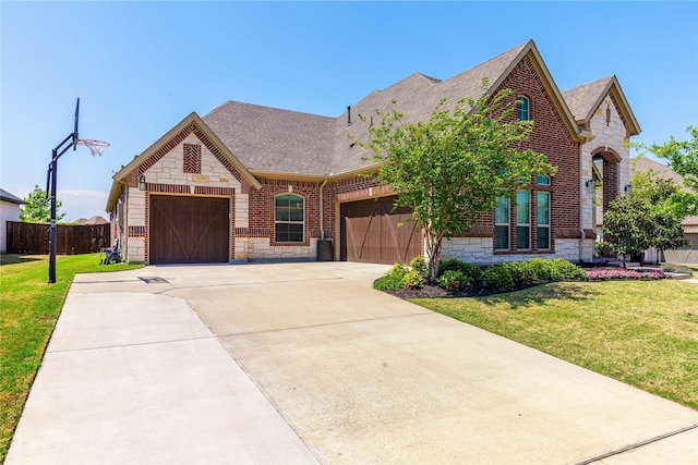 749 Lazy Brooke Dr, Rockwall, TX 75087 - french country inspired facade with a front lawn, driveway, stone siding, brick siding, and a garage