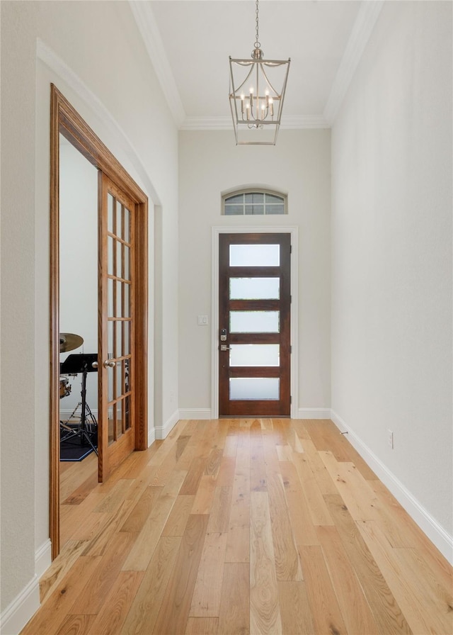 749 Lazy Brooke Dr, Rockwall, TX 75087 - entrance foyer with light wood-style flooring, baseboards, a notable chandelier, and ornamental molding