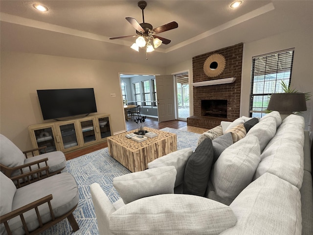 3308 Omega Dr, Tyler, TX 75701 - living room featuring a raised ceiling, ceiling fan, wood finished floors, recessed lighting, and a fireplace