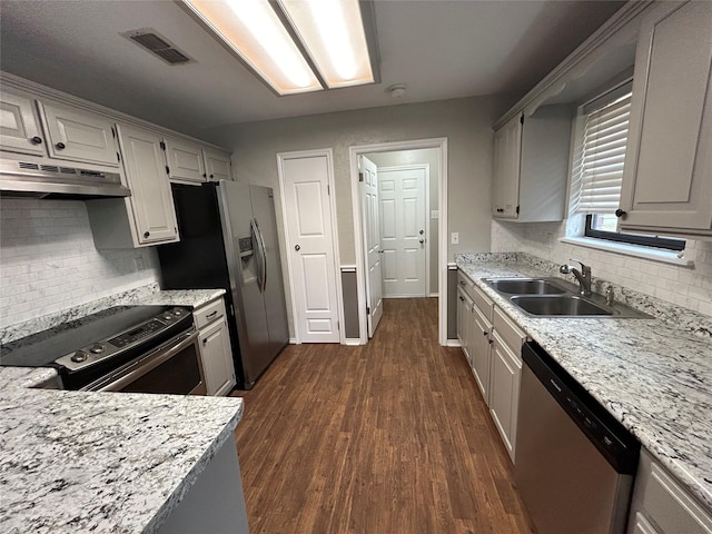 3308 Omega Dr, Tyler, TX 75701 - kitchen with stainless steel appliances, under cabinet range hood, dark wood-type flooring, backsplash, and light stone countertops