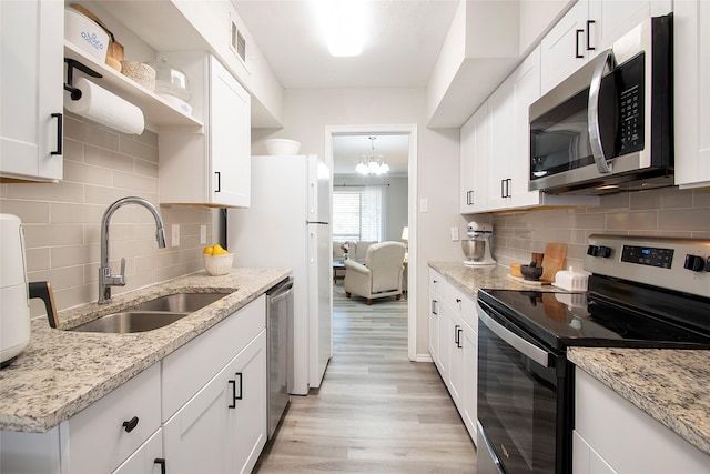 11114 Valleydale Dr Unit D, Dallas, TX 75230 - kitchen with stainless steel appliances, a sink, light wood-style flooring, tasteful backsplash, and white cabinetry