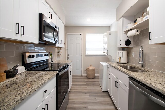 11114 Valleydale Dr Unit D, Dallas, TX 75230 - kitchen with appliances with stainless steel finishes, a sink, white cabinets, baseboards, and decorative backsplash