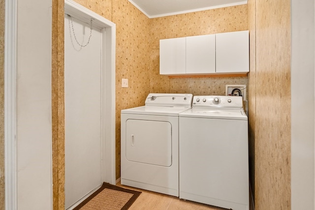 washroom featuring washing machine and clothes dryer, crown molding, and cabinet space