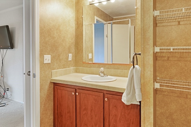 full bathroom featuring a shower stall, vanity, and ornamental molding