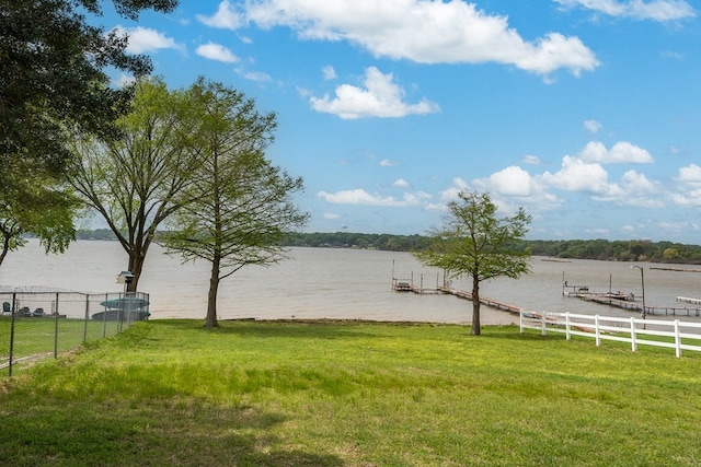 view of water feature featuring a dock and fence