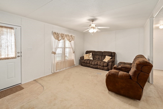 carpeted living area with ceiling fan