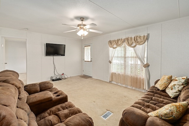 carpeted living area with visible vents and ceiling fan
