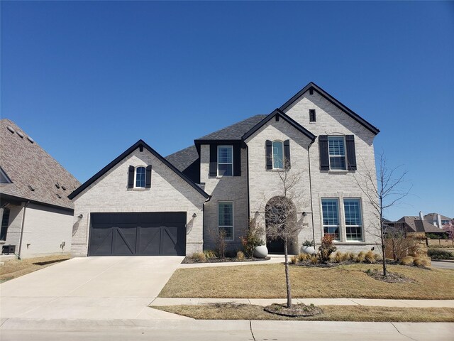 1645 Lilac Ln, Celina, TX 75009 - french country inspired facade featuring driveway, brick siding, a front lawn, and an attached garage