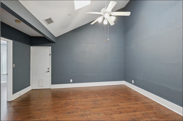 empty room with lofted ceiling with skylight, hardwood / wood-style floors, ceiling fan, baseboards, and visible vents