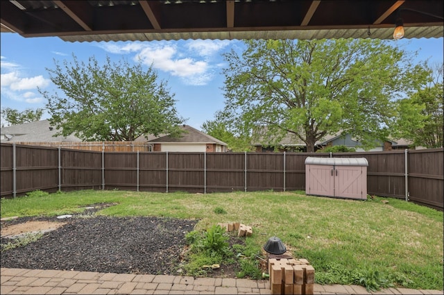 view of yard with a fenced backyard and a storage shed