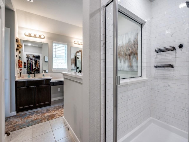 bathroom featuring a spacious closet, vanity, tile patterned flooring, and a stall shower