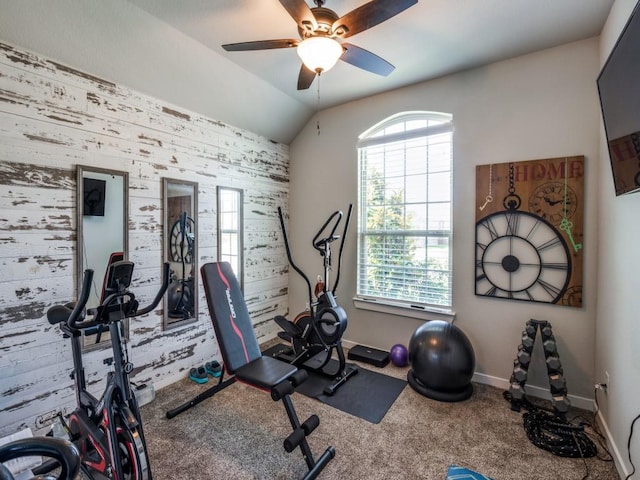 exercise area with lofted ceiling, an accent wall, carpet floors, baseboards, and ceiling fan