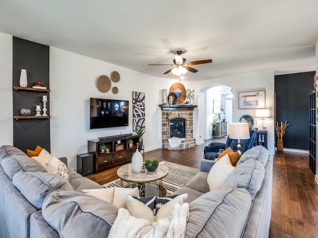 living room featuring arched walkways, wood finished floors, and a ceiling fan