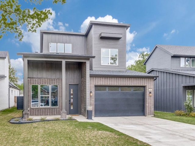 view of front facade featuring brick siding, concrete driveway, and a front yard