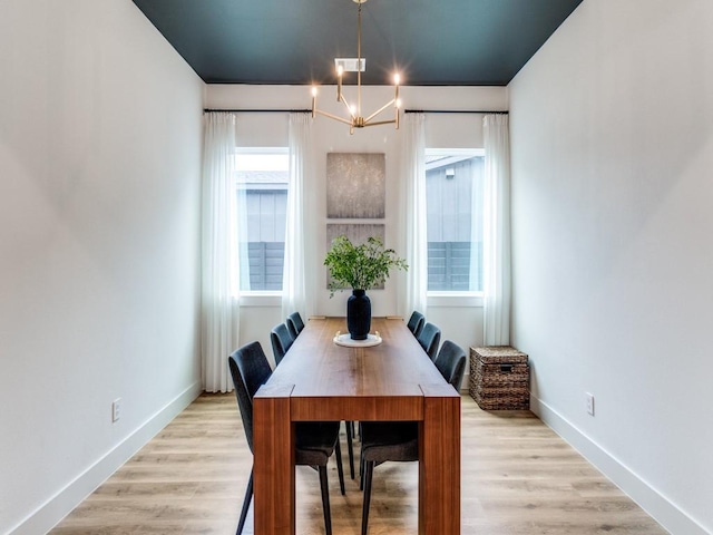 dining room featuring baseboards, a chandelier, and light wood-type flooring
