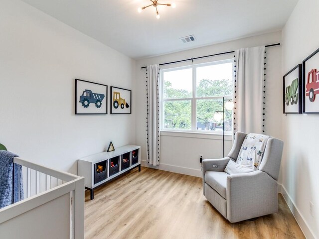 living area with baseboards, visible vents, and light wood-type flooring