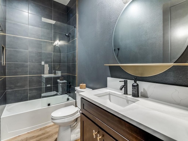 full bathroom with toilet,  shower combination, wood finished floors, and vanity
