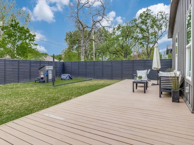 wooden deck with a lawn and fence