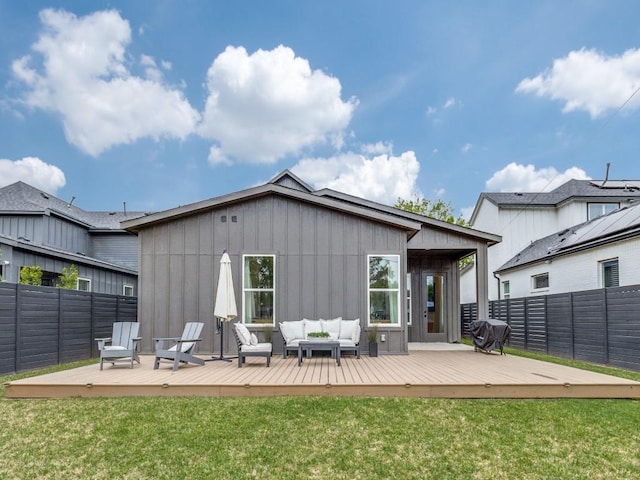 back of house featuring outdoor lounge area, a fenced backyard, a deck, and a lawn