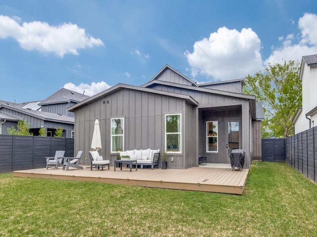 back of property featuring an outdoor living space, a wooden deck, a lawn, and a fenced backyard
