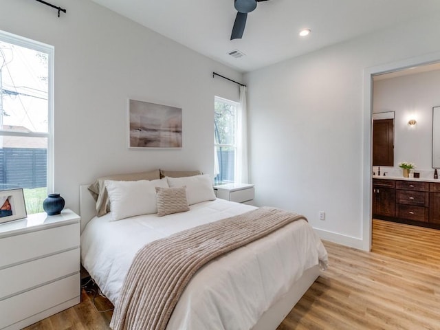 bedroom with light wood-type flooring, recessed lighting, baseboards, ensuite bath, and visible vents