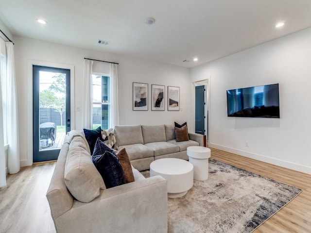 living room with baseboards, visible vents, wood finished floors, and recessed lighting