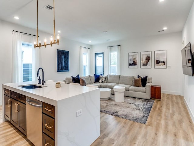 kitchen featuring recessed lighting, light wood-type flooring, light countertops, and a sink