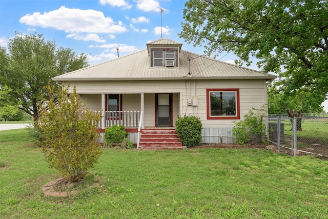 view of front facade with metal roof, fence, a porch, and a front yard