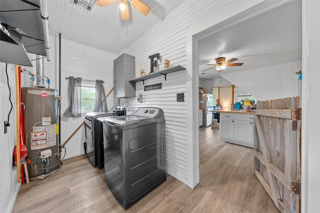washroom with gas water heater, laundry area, a ceiling fan, light wood-type flooring, and washer and dryer