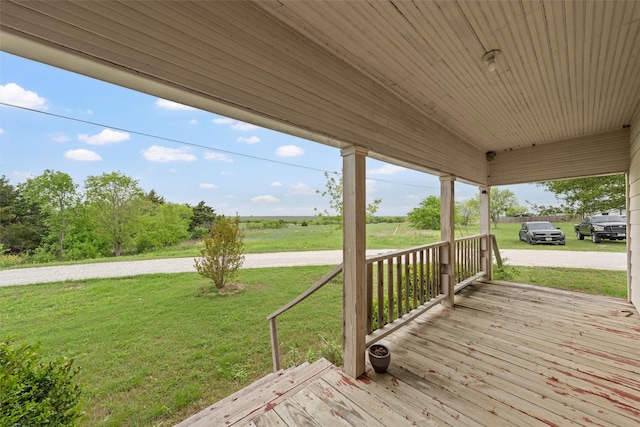 wooden deck featuring a yard and a rural view