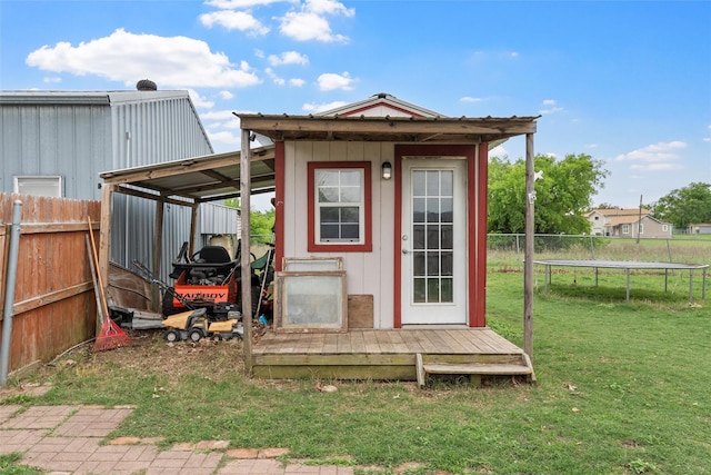 view of outbuilding with an outbuilding, fence, and a trampoline