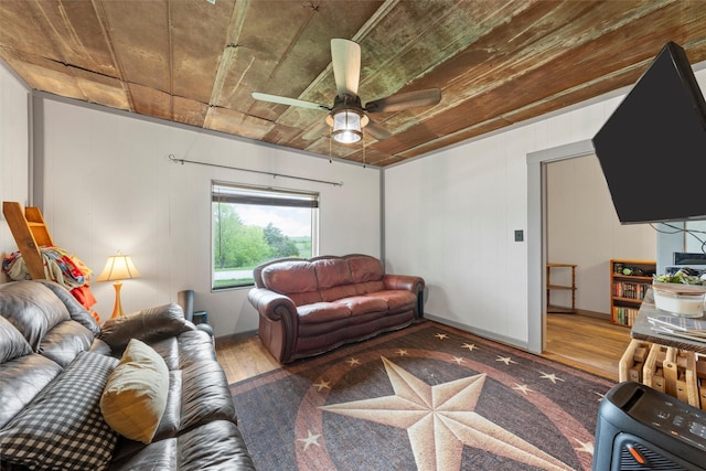 living area featuring heating unit, wood finished floors, and a ceiling fan