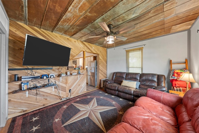 living area with wooden ceiling, ceiling fan, and wooden walls
