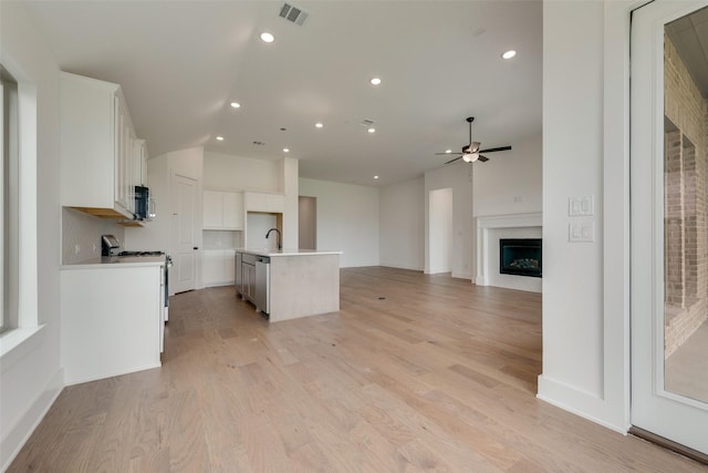 kitchen featuring ceiling fan, visible vents, appliances with stainless steel finishes, open floor plan, and white cabinetry