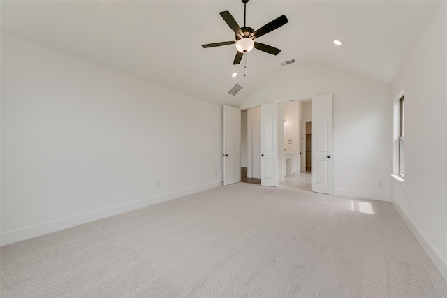 unfurnished bedroom with light colored carpet, baseboards, visible vents, and vaulted ceiling