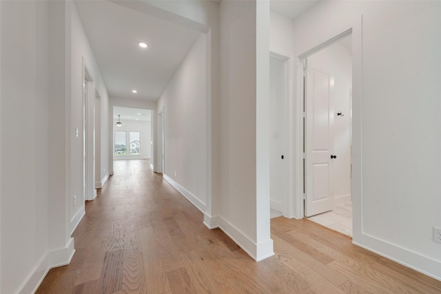corridor featuring recessed lighting, baseboards, and light wood-type flooring