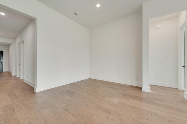 spare room with recessed lighting, light wood finished floors, baseboards, and visible vents