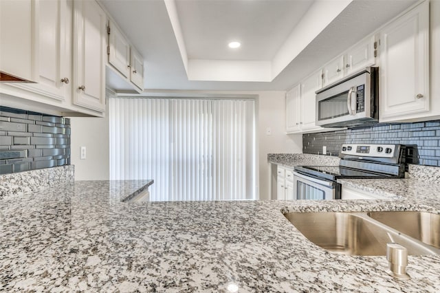 4539 N O Connor Rd Unit 2233, Irving, TX 75062 - kitchen featuring stainless steel appliances, white cabinetry, tasteful backsplash, and a tray ceiling