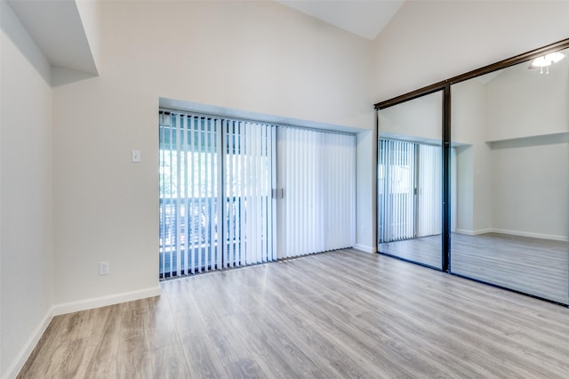 4539 N O Connor Rd Unit 2233, Irving, TX 75062 - unfurnished room with high vaulted ceiling, wood finished floors, healthy amount of natural light, and baseboards