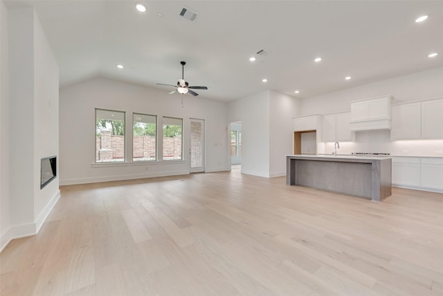 1151 Nora Ln, Forney, TX 75126 - unfurnished living room with recessed lighting, a ceiling fan, a glass covered fireplace, light wood-style floors, and baseboards