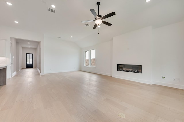 1151 Nora Ln, Forney, TX 75126 - unfurnished living room featuring a glass covered fireplace, lofted ceiling, light wood-style flooring, baseboards, and a ceiling fan