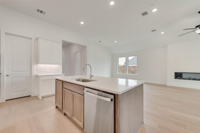 1151 Nora Ln, Forney, TX 75126 - kitchen with stainless steel dishwasher, a sink, a center island with sink, light wood finished floors, and ceiling fan