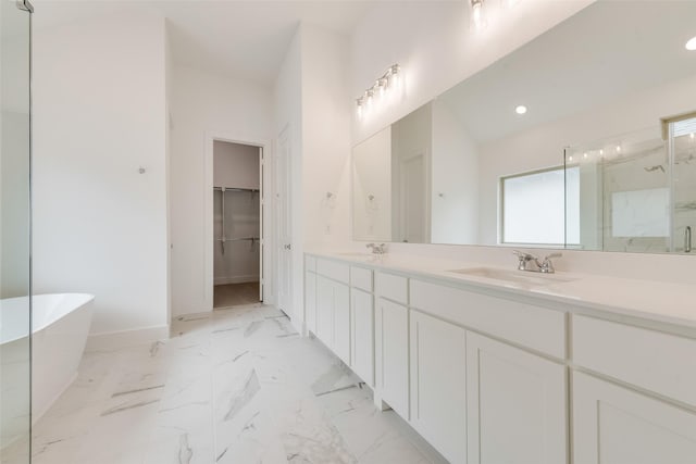1151 Nora Ln, Forney, TX 75126 - full bath with a marble finish shower, a freestanding bath, baseboards, double vanity, and a walk in closet