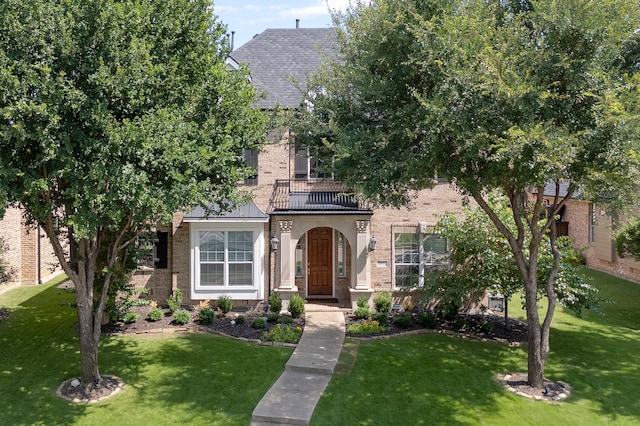 1891 Mustang Trl, Frisco, TX 75033 - view of property hidden behind natural elements with brick siding, a balcony, and a front yard