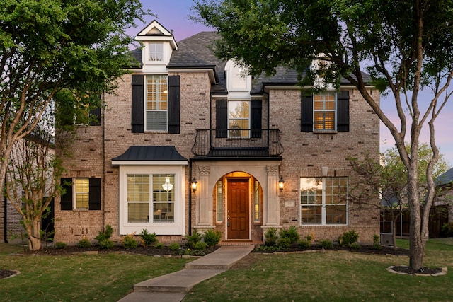 view of front facade featuring a yard and brick siding